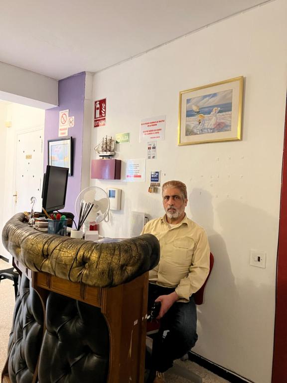Ein Mann, der in einem Friseursalon mit einem Waschbecken sitzt. in der Unterkunft pensión La Parada in Alicante