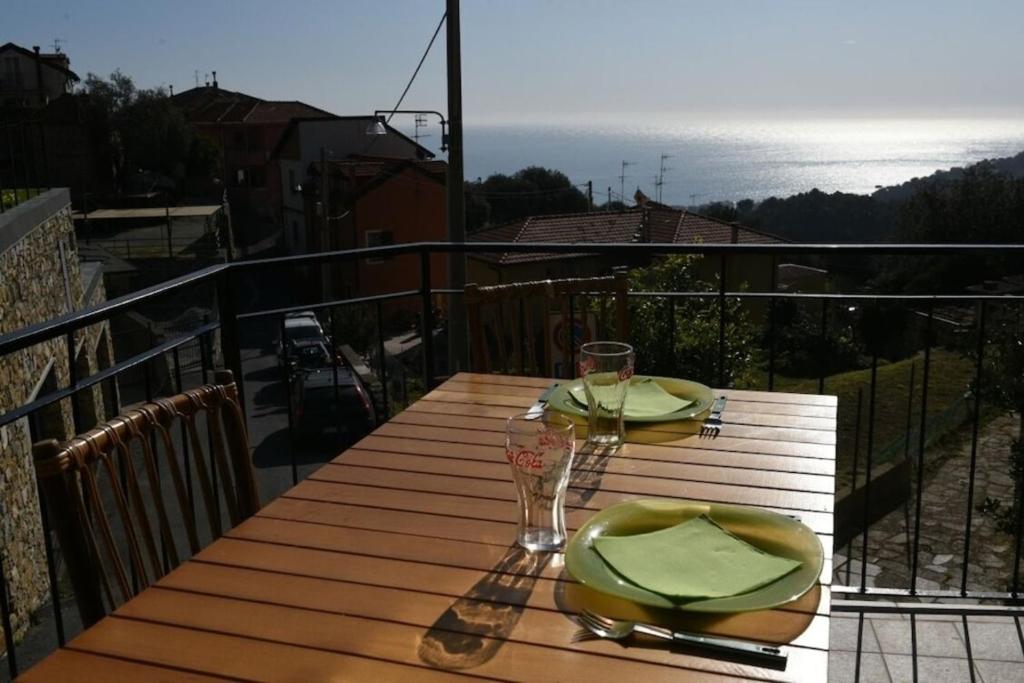 a table on a balcony with a view of the ocean at The Family Free Parking in Alassio in Alassio