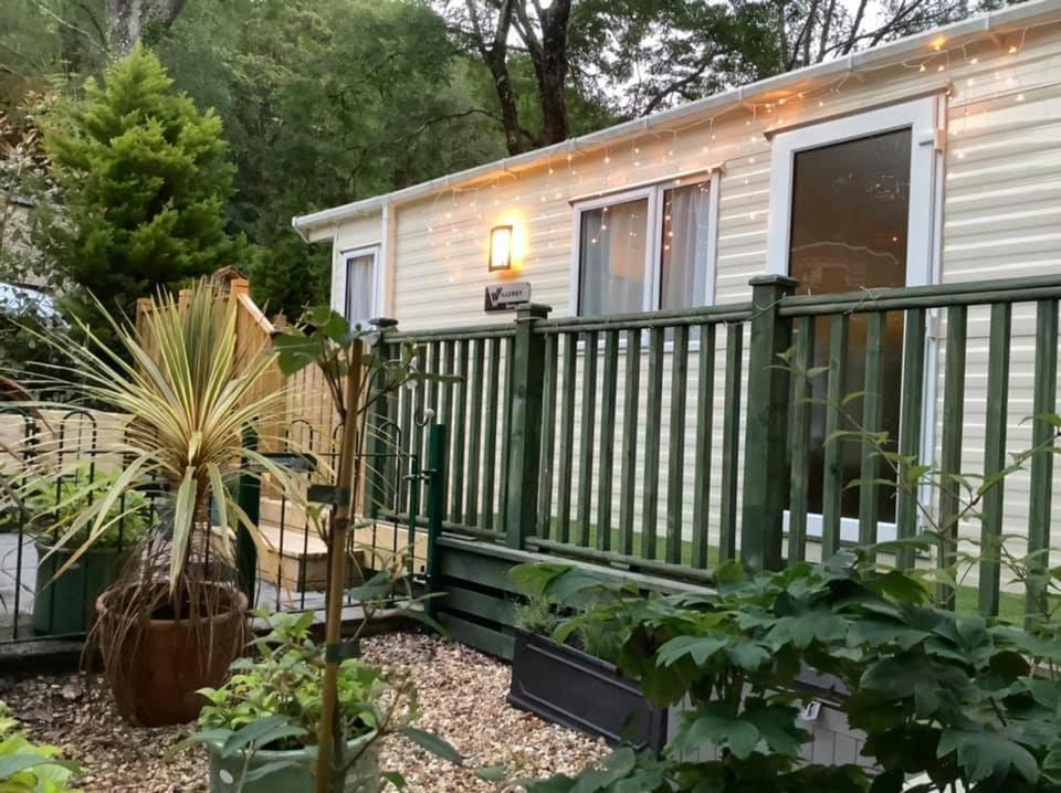 a tiny house with a green railing at 173A Woodland Way in Porthmadog