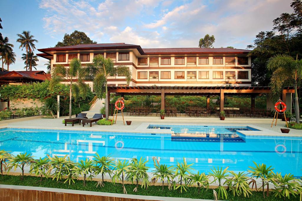 una casa grande con piscina frente a ella en Hotel Tropika en Dávao