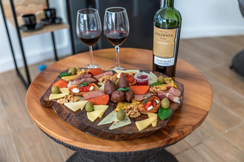 einen Teller mit Essen und zwei Gläsern Wein in der Unterkunft Badu Lodge Puriscal in Santiago