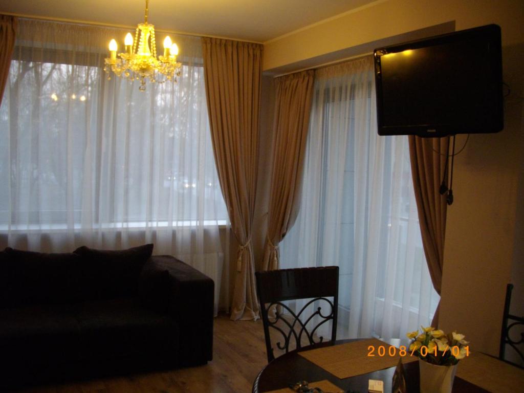 - un salon avec un canapé et un lustre dans l'établissement Centro apartamentai - Vingio apartamentai, à Vilnius