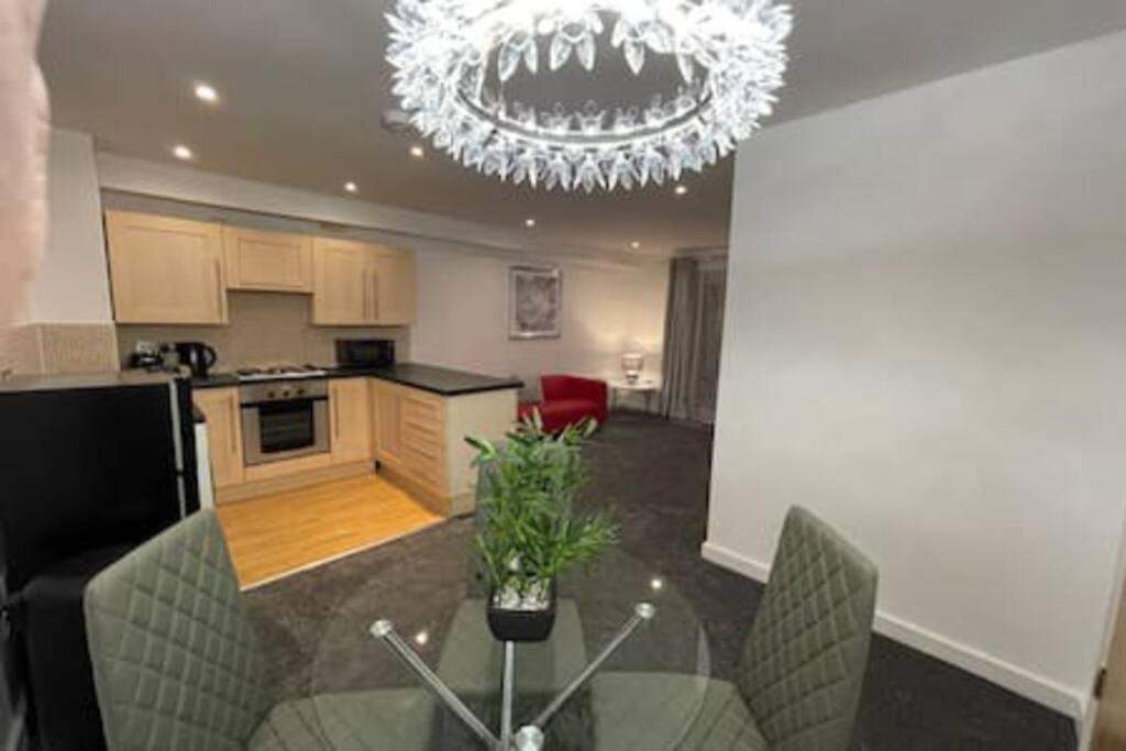 a kitchen with a glass table and a chandelier at Moda Wigan 2 - Stylish 2 Bed in Central Wigan in Wigan