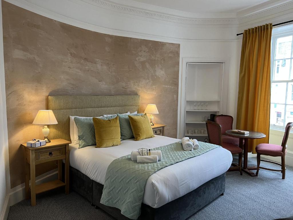 a bedroom with a large bed with two towels on it at Royal Suites Kirkcudbright in Kirkcudbright