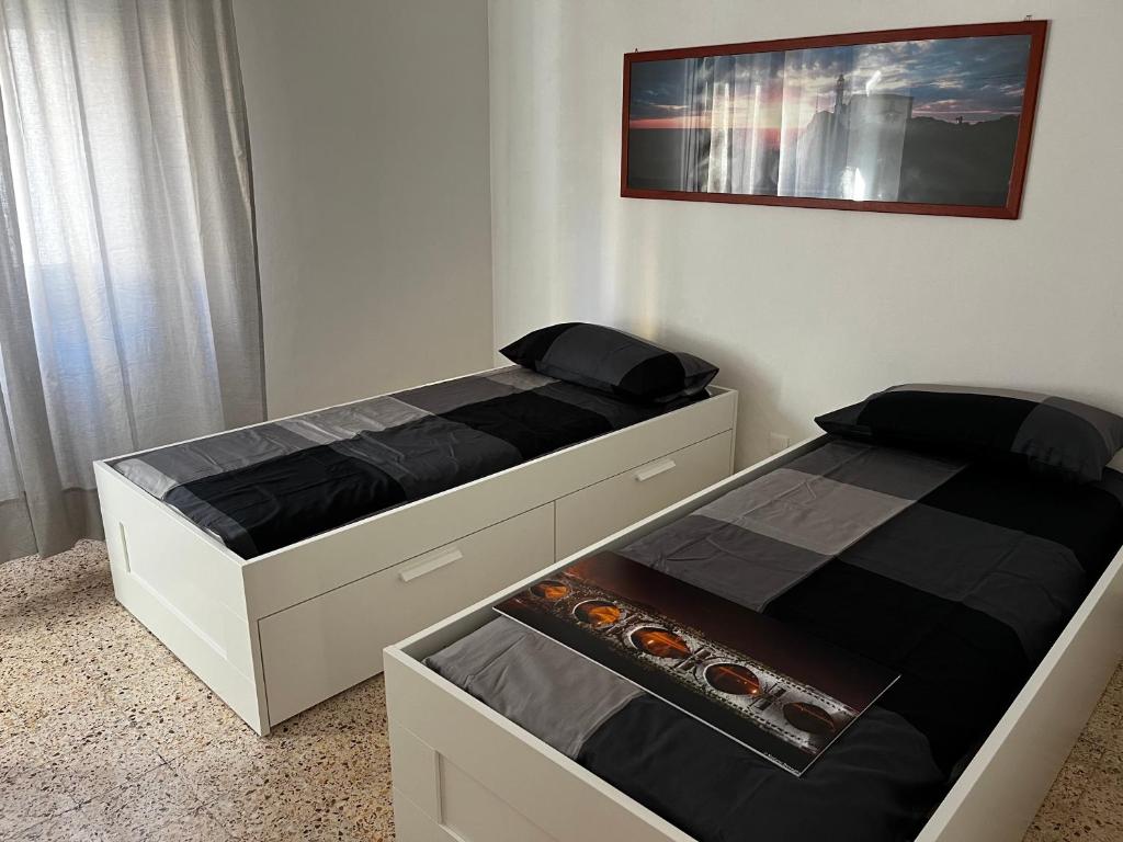 2 Einzelbetten in einem Schlafzimmer mit einem Bild an der Wand in der Unterkunft Casa Vacanze Dalla Lory in Rimini