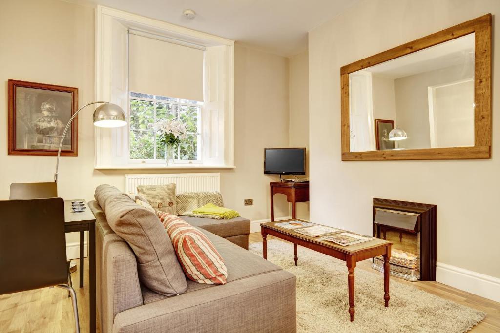 a living room with a couch and a mirror at Ludwick Apartment in Shrewsbury