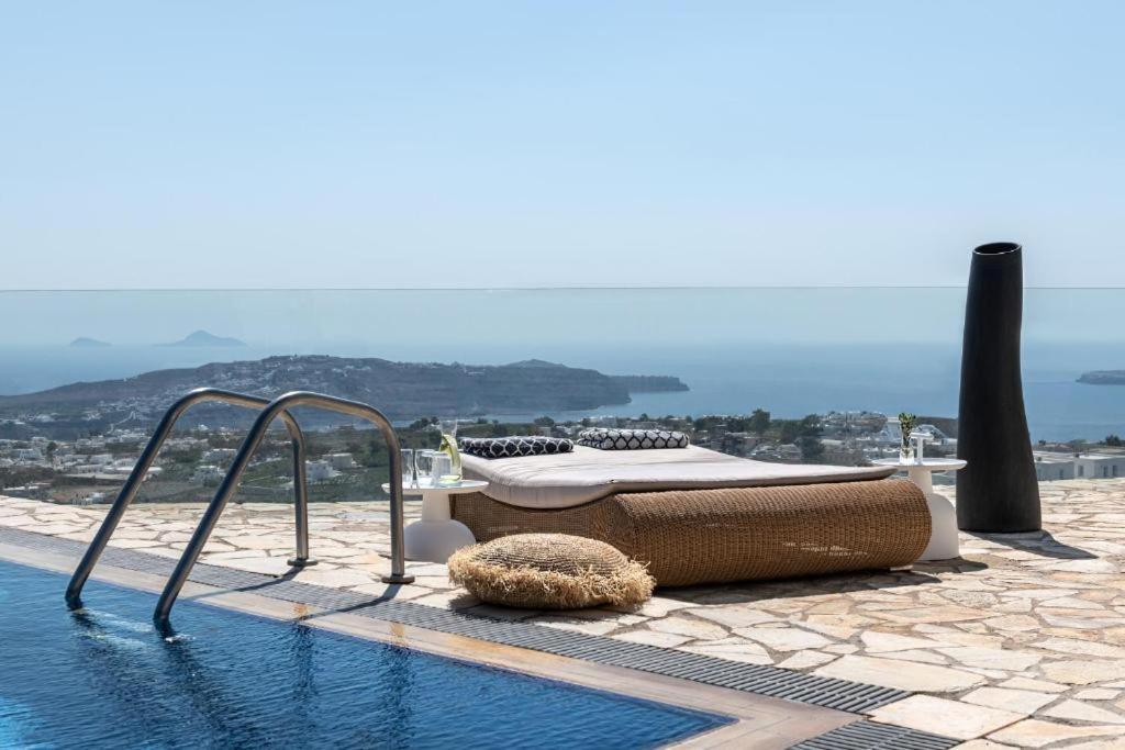 a swimming pool with a bed and a pool at Smy Santorini Suites & Villas in Pyrgos