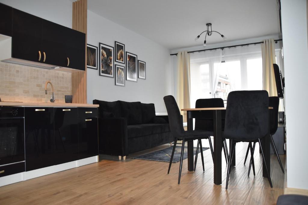 cocina y sala de estar con mesa y sillas en Apartament Kadzielnia, en Kielce