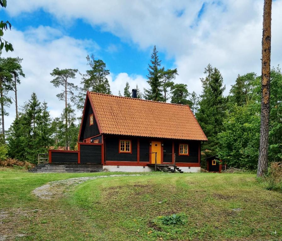 a small house with an orange roof on a field at Genuine house on northern Gotland near Slite in Lärbro