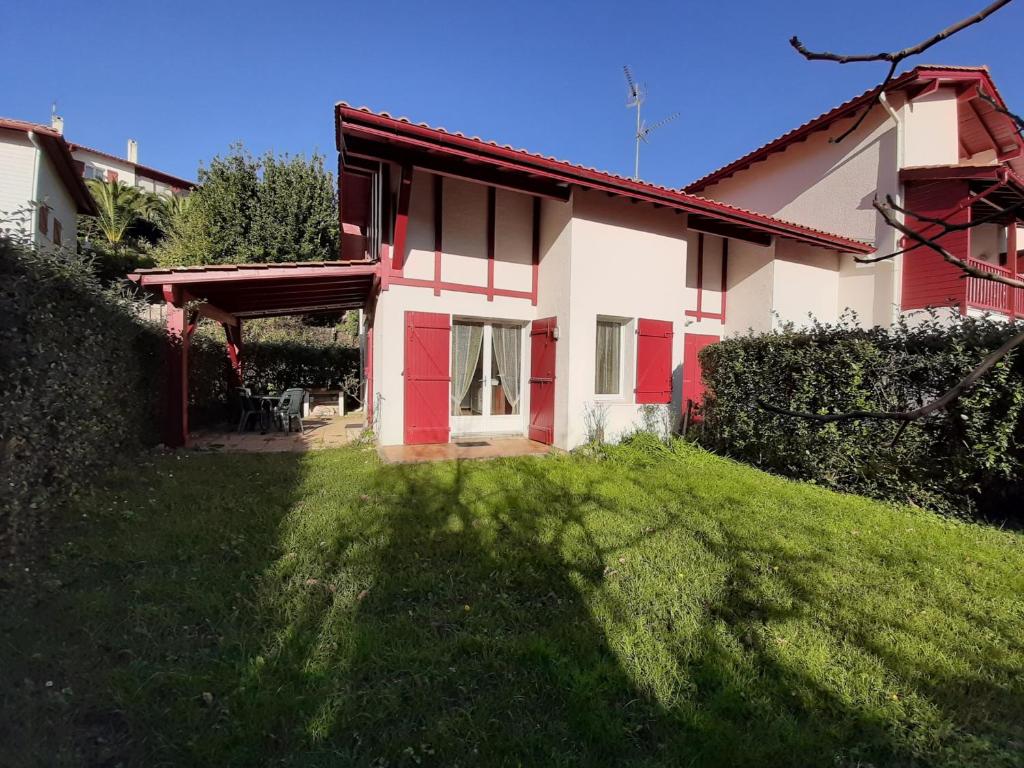 ein rotes und weißes Haus mit einem grünen Hof in der Unterkunft Maison Urrugne, 3 pièces, 4 personnes - FR-1-239-596 in Urrugne