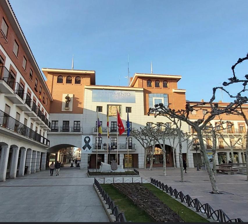 budynek w mieście z ludźmi chodzącymi po nim w obiekcie Como en casa en el centro de Torrejón w mieście Torrejón de Ardoz
