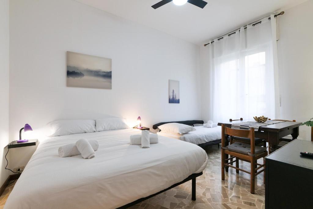biała sypialnia z łóżkiem i biurkiem w obiekcie PrimoPiano - Romilli w Mediolanie