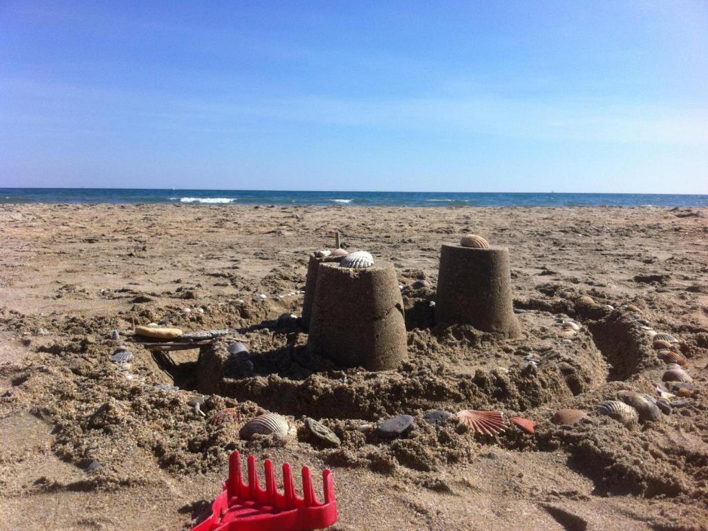 a sand castle on a beach with the ocean in the background at Studio Sète, 1 pièce, 4 personnes - FR-1-338-406 in Sète