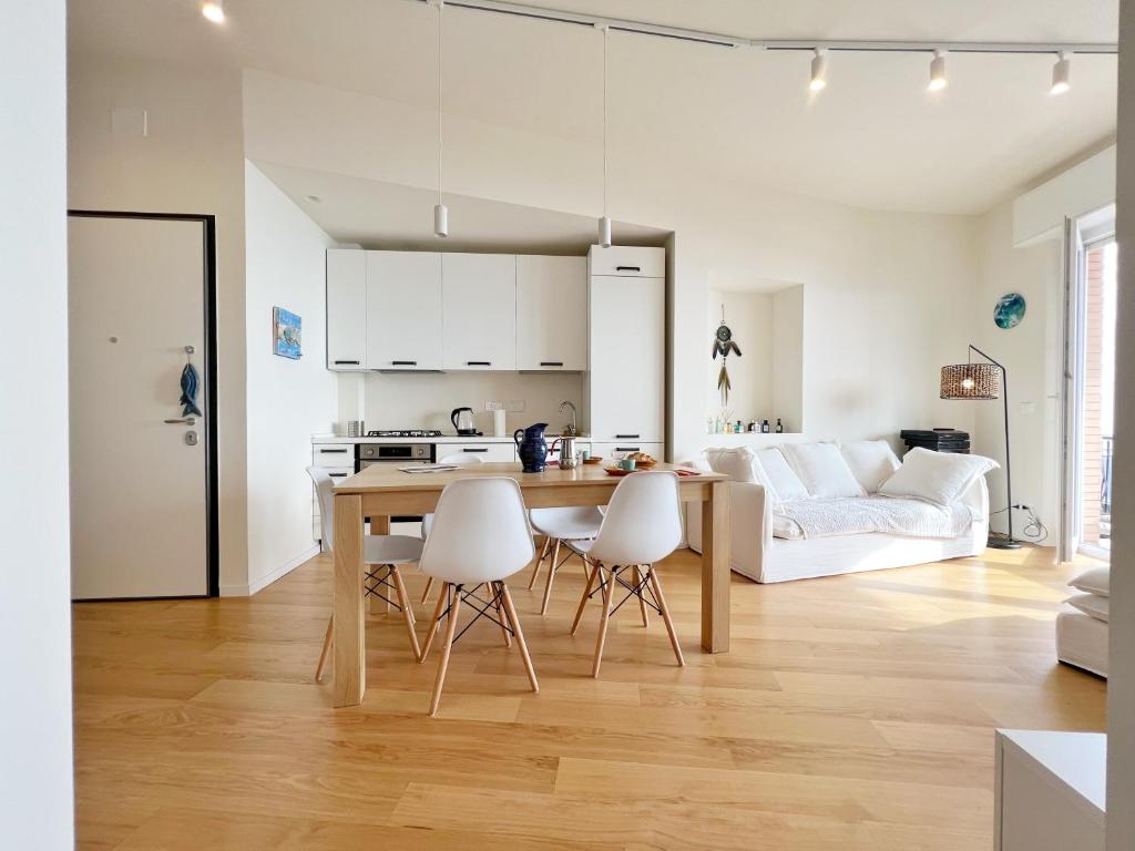 a kitchen and living room with a table and chairs at Seaside Luxury Apartment by Holiday World in Cogoleto