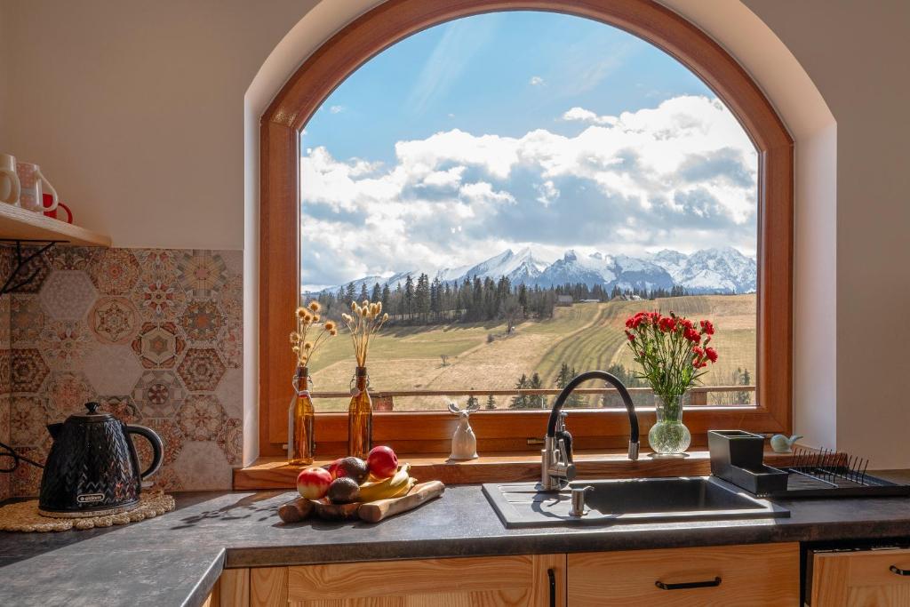 a kitchen with a window with a mountain view at Willa Montana - apartament widokowy w Bukowinie Tatrzańskiej in Bukowina Tatrzańska
