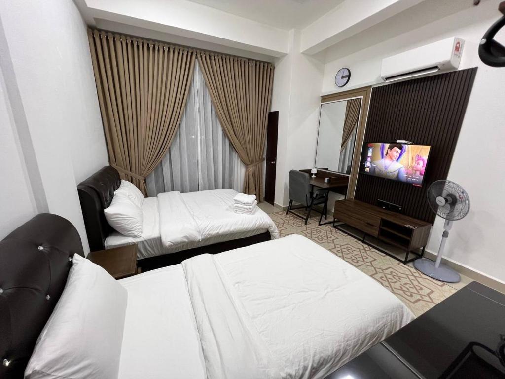 グア・ムサンにあるHASSMA Studio Apartment with Poolのベッド2台、薄型テレビが備わるホテルルームです。