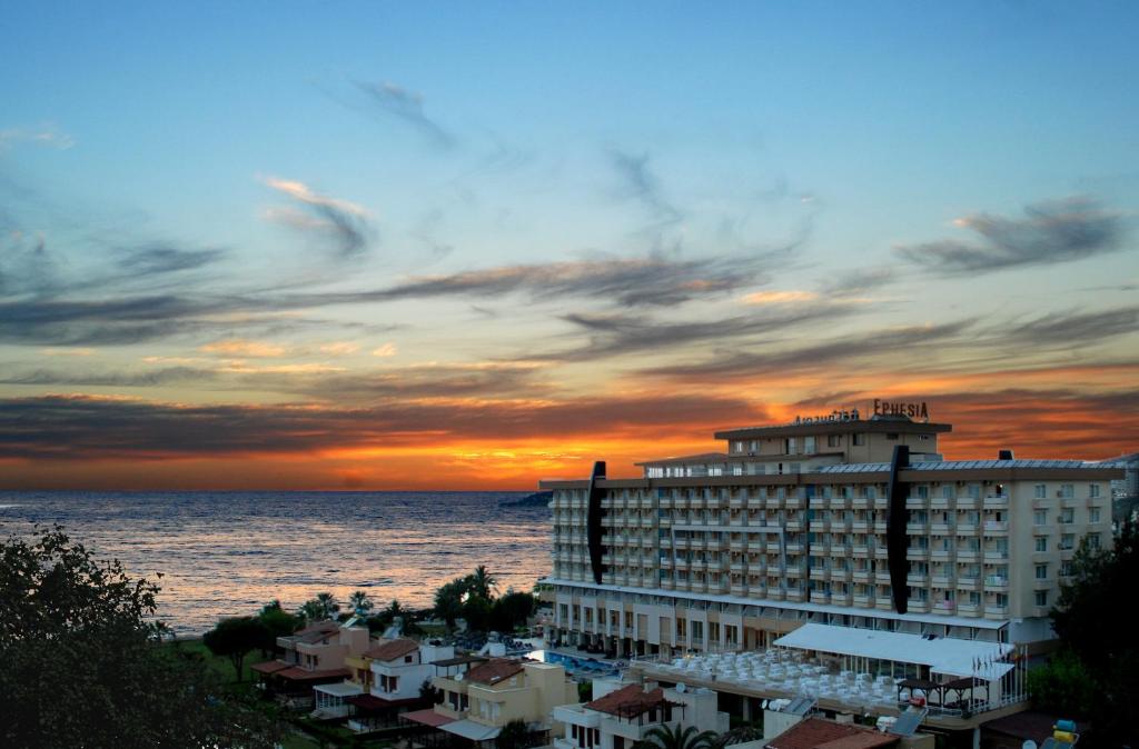 Blick auf ein Hotel und das Meer bei Sonnenuntergang in der Unterkunft Ephesia Hotel - All Inclusive in Kusadası