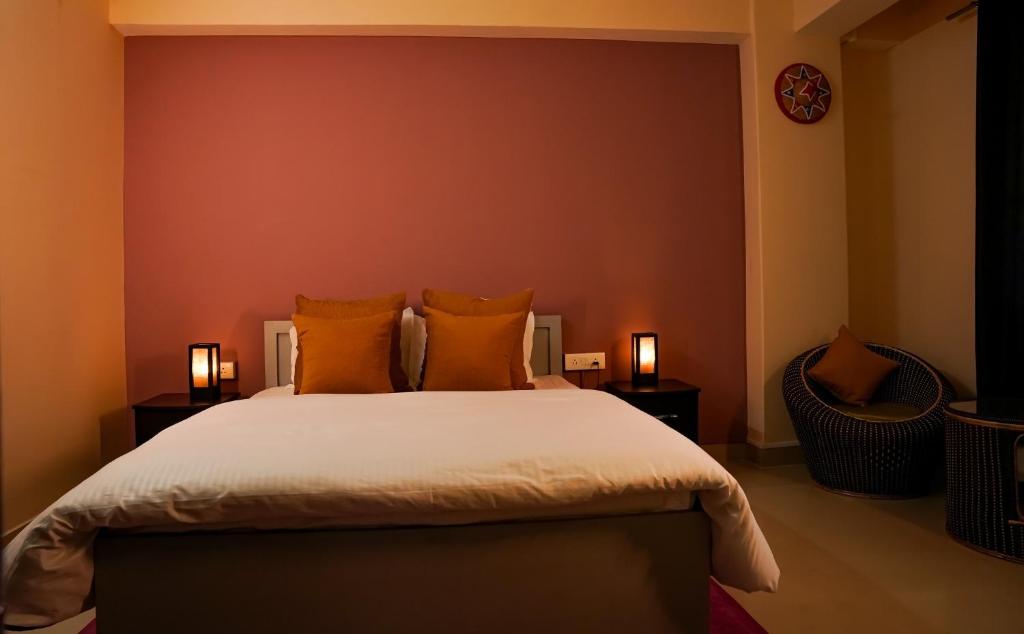 a bedroom with a large bed with orange pillows at Yellow Sapphire, Premium Sikkimese Homestay in Gangtok