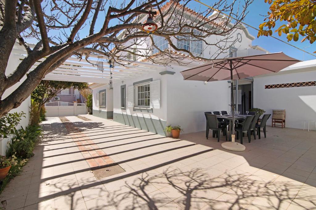 un patio con mesa y sombrilla en Villa Galé, en Guia
