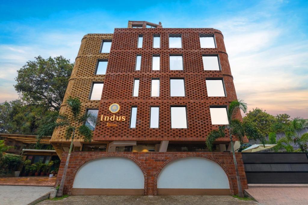 a red brick building with a clock on it at Indus Suites in Nagpur