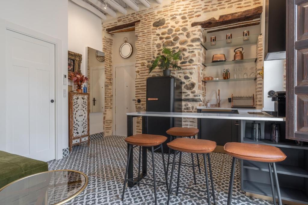 a kitchen with a counter and stools in a room at tuGuest Puerta del Dauro Apartment in Granada