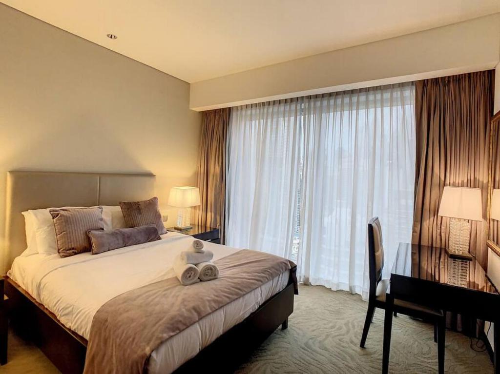 a hotel room with a large bed and a desk at Key View - Emaar Residences, Marina Mall in Dubai