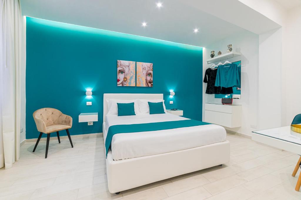 1 dormitorio azul con 1 cama y 1 silla en I Mori dell’Etna en Giardini Naxos