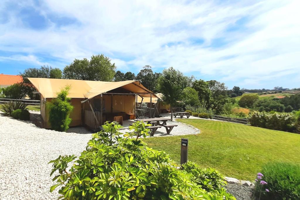 a tent with a picnic table in a field at Silver Coast Glamping luxury lodge in Alcobaça