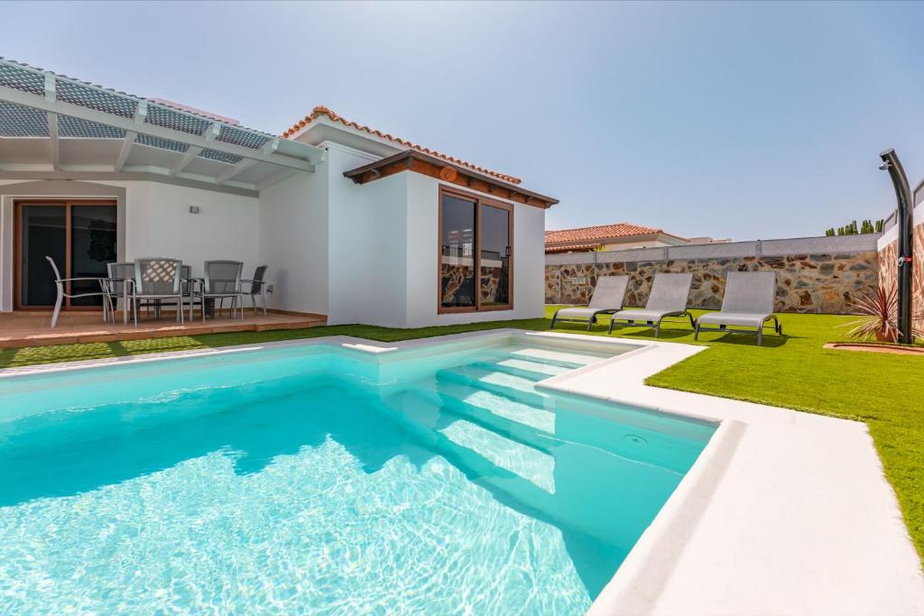 a villa with a swimming pool and a house at Villa Luxury Paula's Dream Private Pool Corralejo By Holidays Home in Corralejo