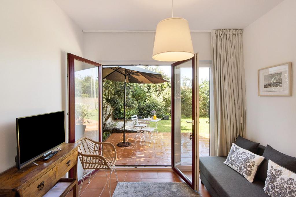 a living room with a couch and a television at Praia da Granja - Seaside Beach in Arcozelo