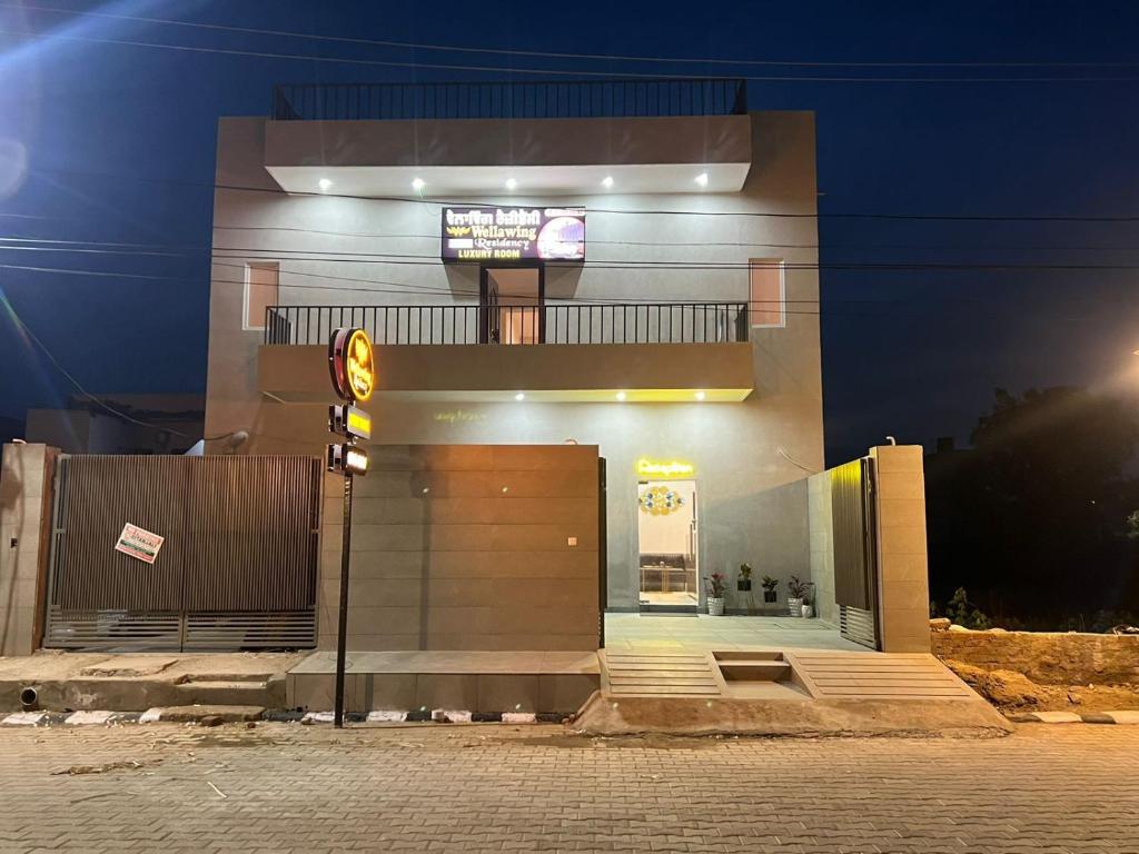 a building with a sign in front of it at night at Wellawing Residency in Ludhiana