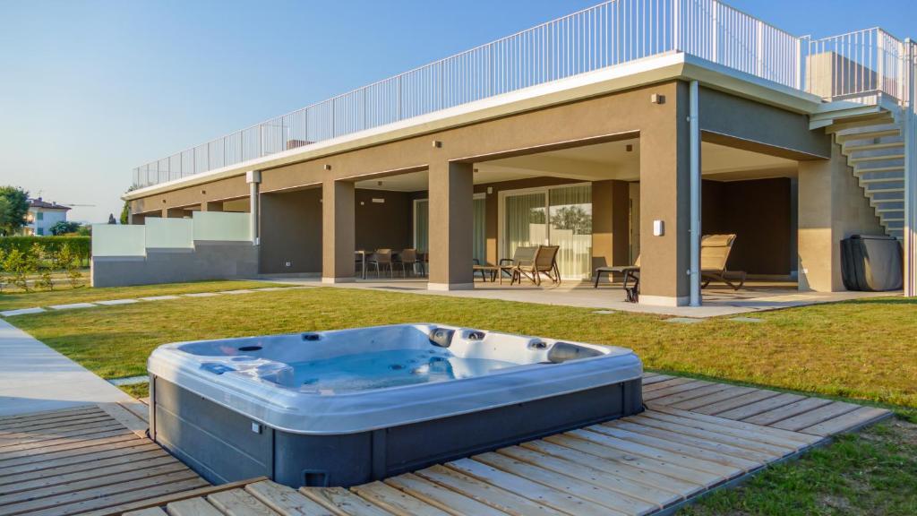 a hot tub on a deck in front of a house at Ville Lazise Ada & Rico in Lazise