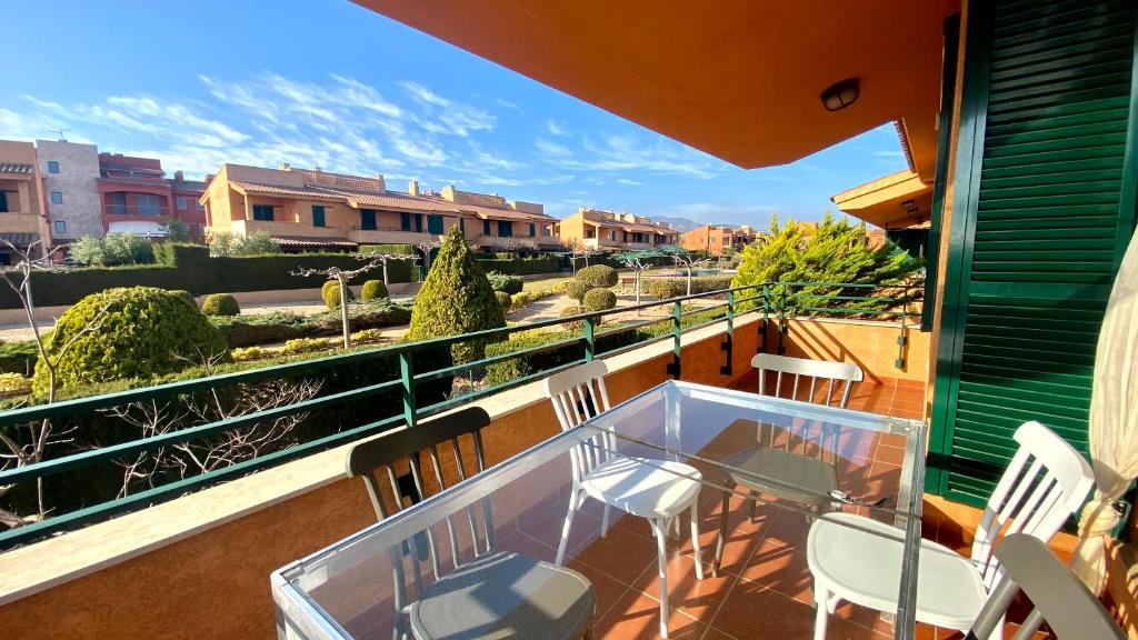 un balcón con una mesa de cristal y sillas. en Acogedor apartamento con altillo MSJ 53, en Calafat