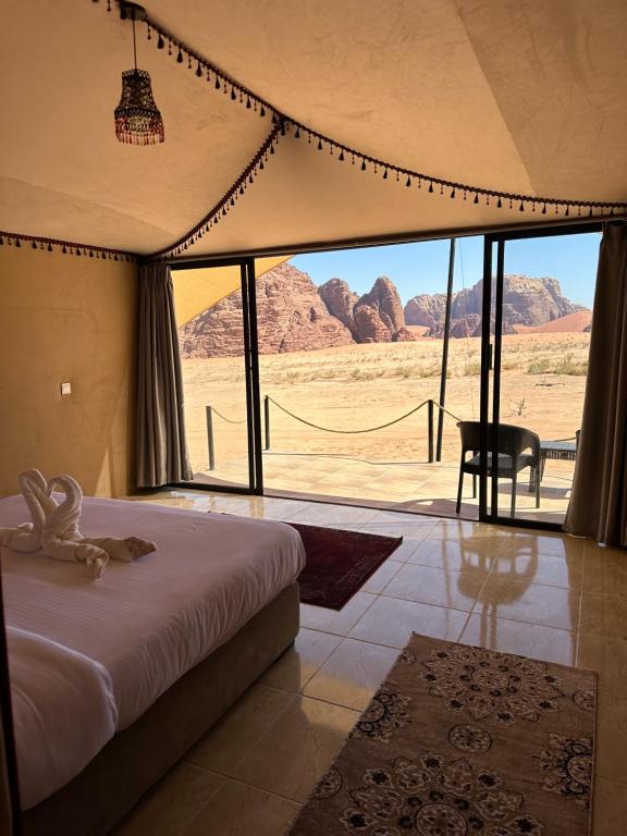 Schlafzimmer mit einem Bett und Blick auf die Wüste in der Unterkunft Wadi Rum Mirror Camp in Wadi Rum