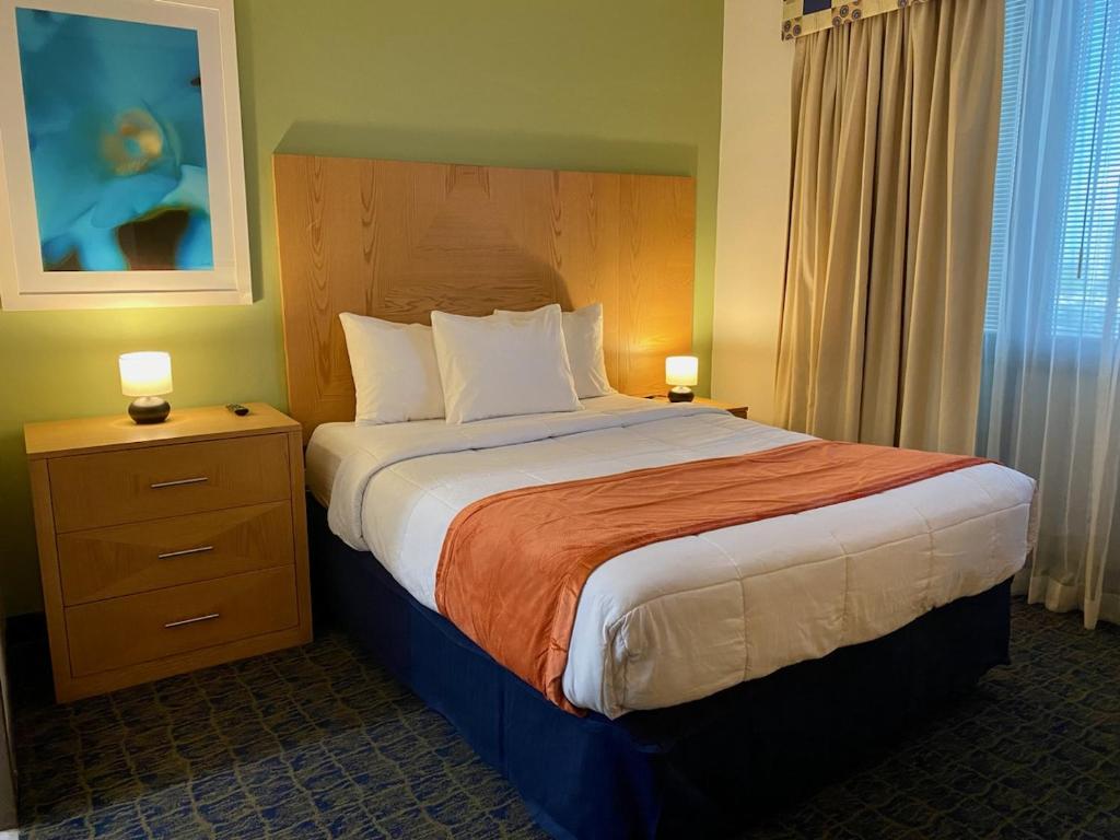 a bedroom with a large bed with two lamps on tables at Ficus Hotel in San Juan