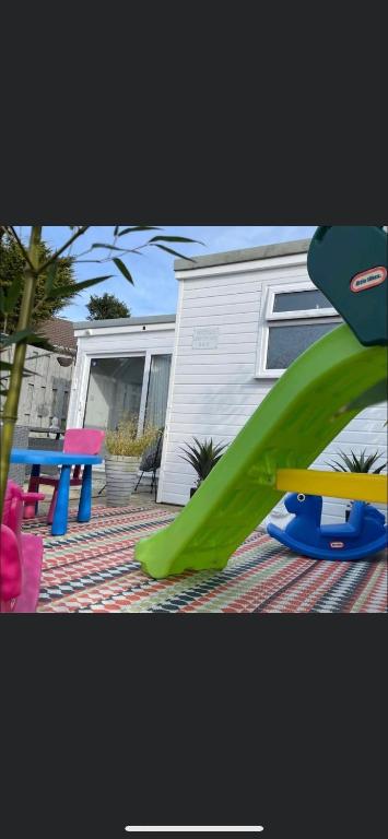 a playground with a green slide and a picnic table at Nicolas Devon air bed and breakfast in Ilfracombe