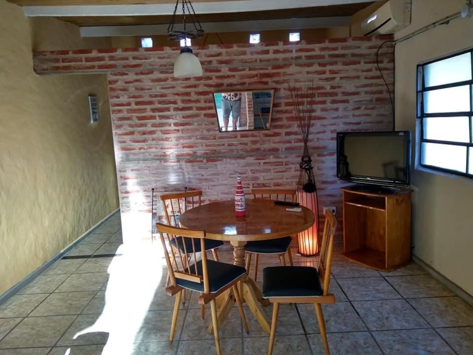 a dining room with a table and chairs and a brick wall at La casita en San Miguel del Monte in San Miguel del Monte