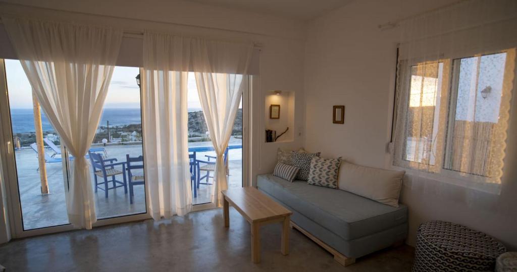 een woonkamer met een bank en uitzicht op de oceaan bij Sea view Villa in Koutsounari