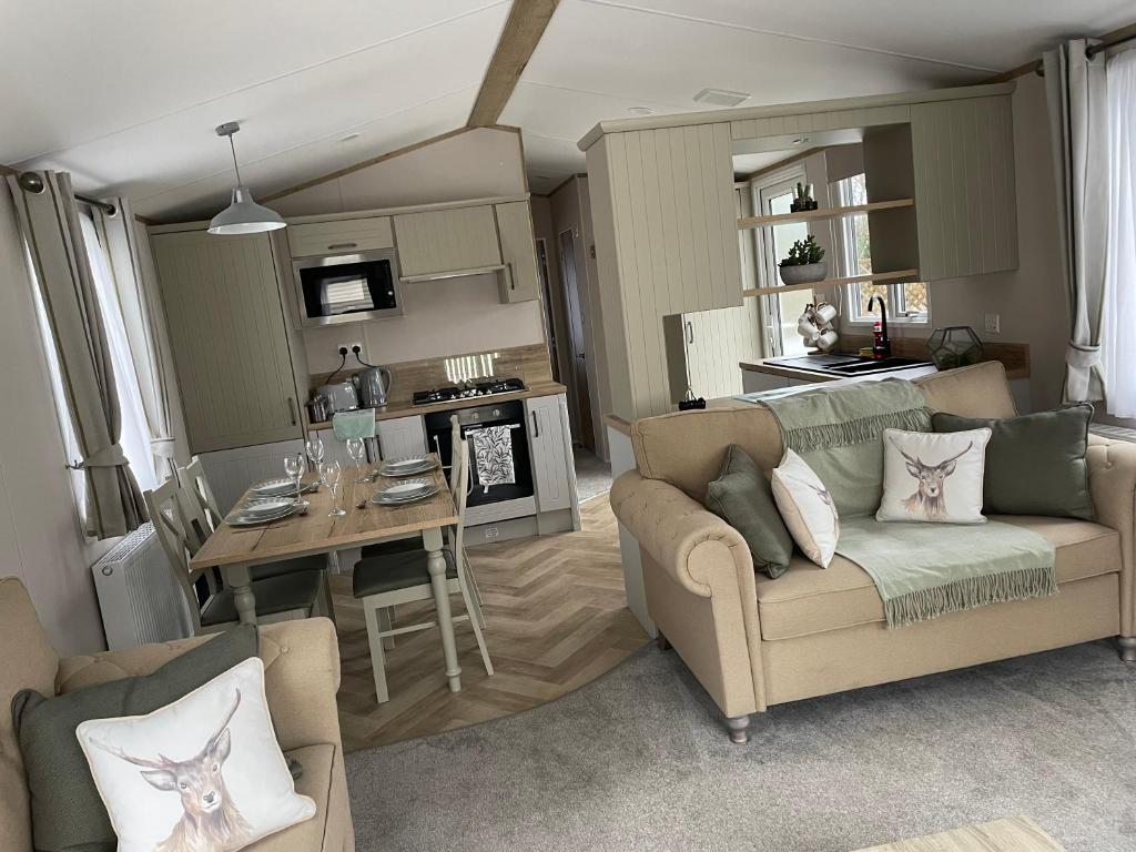 ein Wohnzimmer mit einem Sofa und einem Tisch sowie eine Küche in der Unterkunft The avenue, Waterside in Paignton