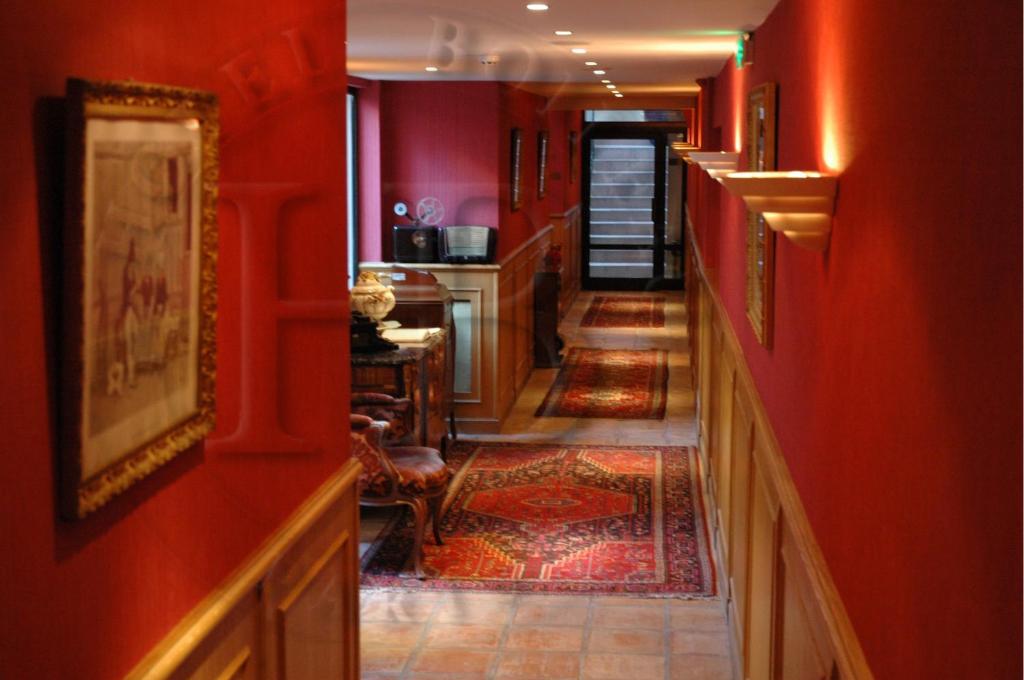 a hallway with red walls and a tile floor at Hotel Boileau in Paris