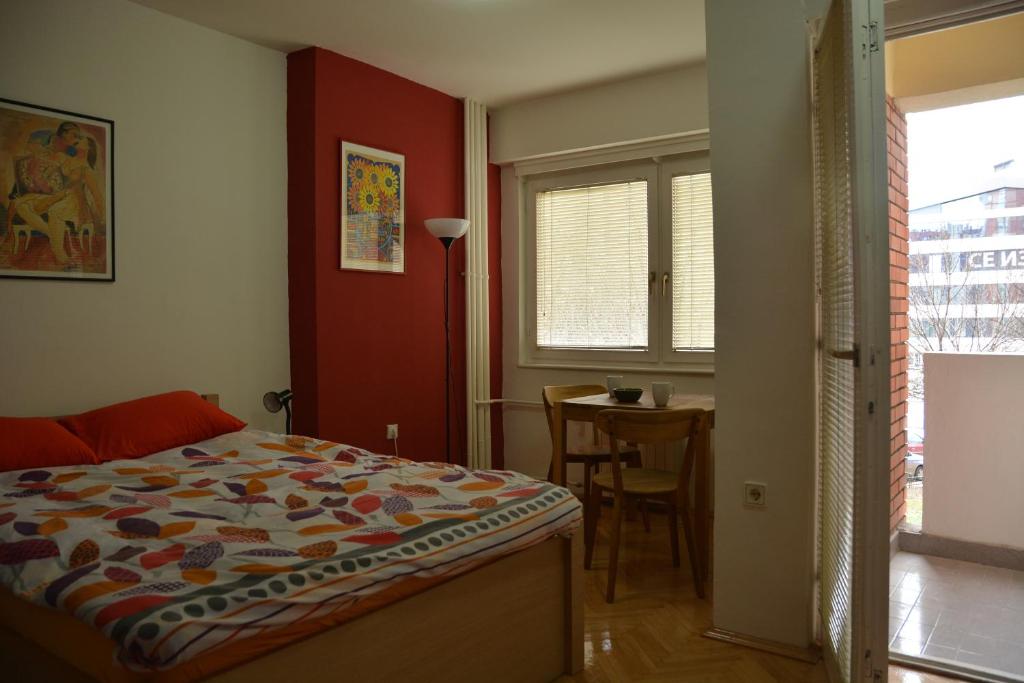 una camera da letto con un letto, un tavolo e una finestra di Apartment Kapishtec a Skopje