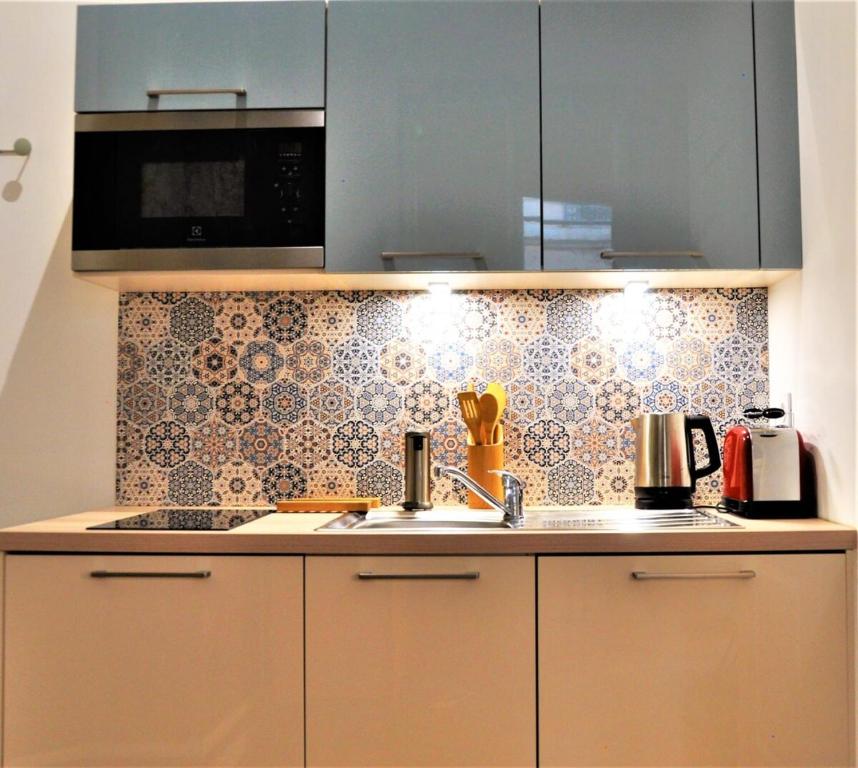 una cocina con fregadero y microondas en Le Bleu hypercentre Presque île, en Lyon