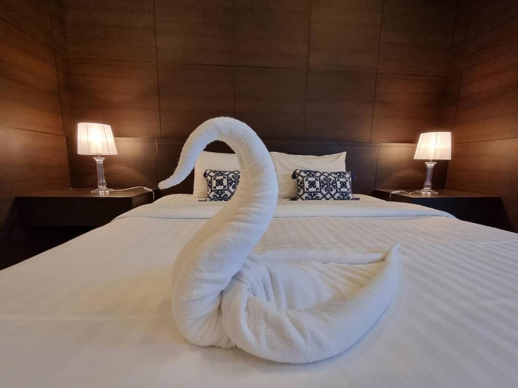 een witte zwaan gemaakt van handdoeken op een bed bij Midas Pool Villa in Jomtien Beach