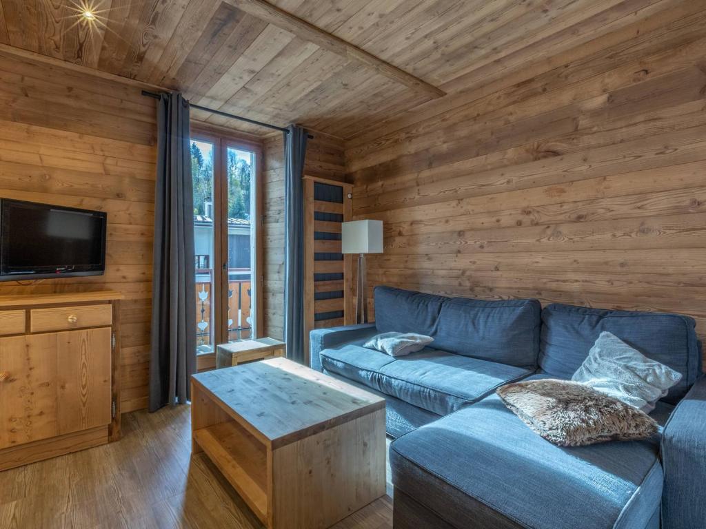 un salon avec un canapé bleu et une télévision dans l'établissement Charmant 4 pièces en centre village, proche pistes - 8 pers, Wifi, parking, balcon, animaux acceptés - FR-1-437-48, à La Clusaz