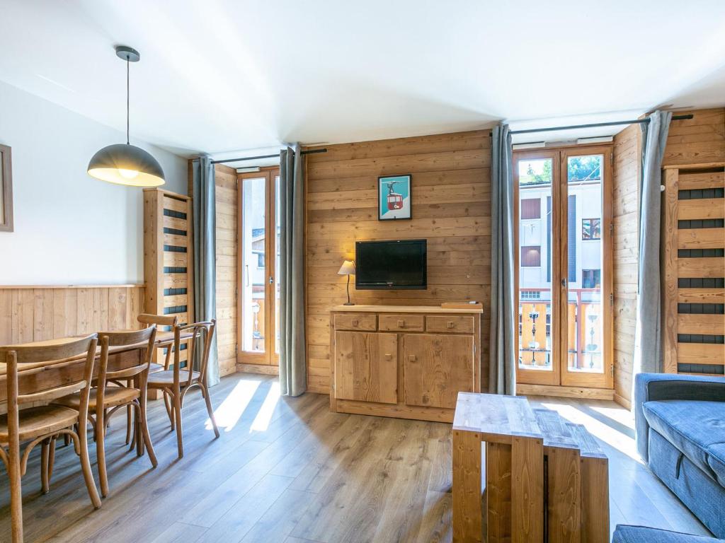 a living room with a tv and a table and chairs at Appartement La Clusaz, 3 pièces, 8 personnes - FR-1-437-25 in La Clusaz