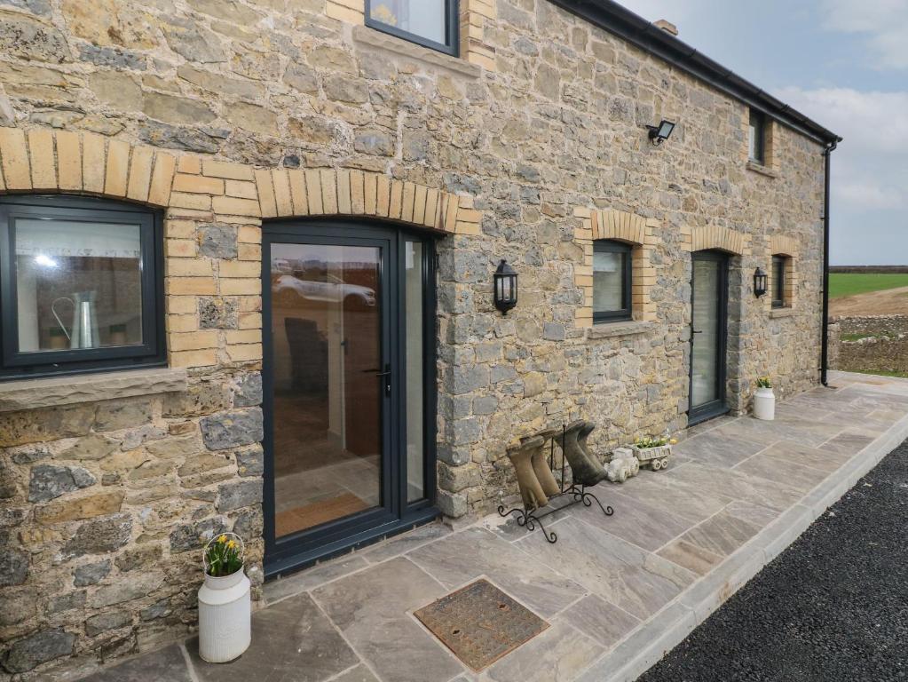 a stone building with sliding glass doors on it at The Granary in Bridgend