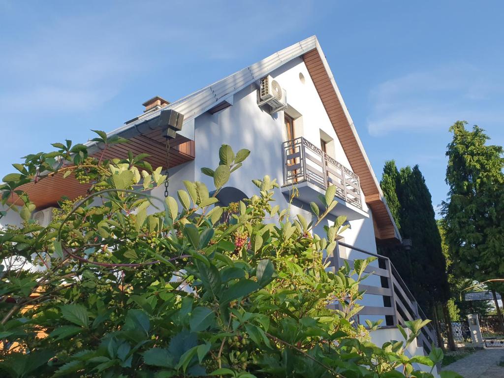 a white building with a balcony and trees at "PRZY PARKU" Dom nad morzem z werandą i ogrodem in Stegna