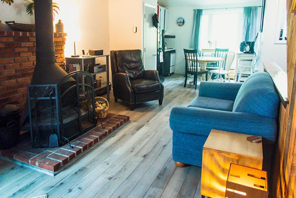 sala de estar con sofá azul y chimenea en Sunset Side, en Campton