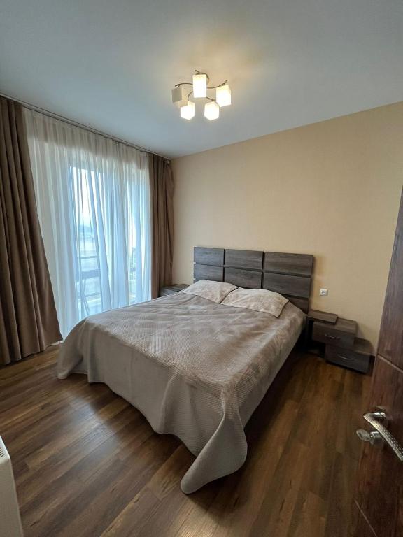 1 dormitorio con cama y ventana grande en Villa Deluxe Premium Apartment 308, en Bakuriani
