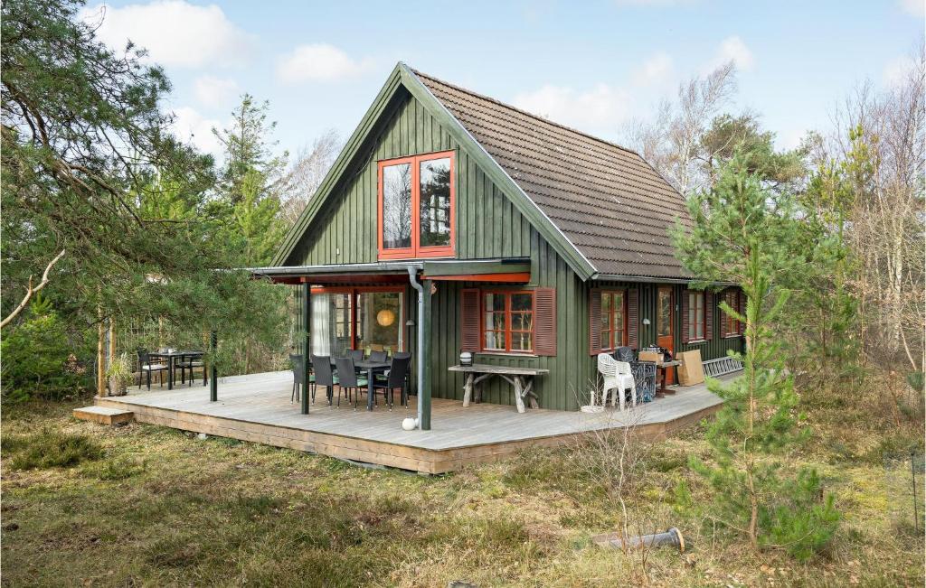 uma casa verde com um deque na floresta em Lovely Home In Hjby With Wifi em Højby